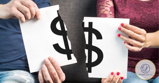 Man and woman holding a poster ripped in half with a dollar sign on it.